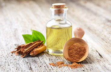 Cinnamon bark with essential oil on wooden background