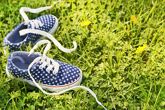 American children's sneakers on green grass background.