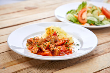 chicken with mashed potatoes and salad on the wooden background