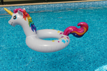 Inflatable unicorn floating in swimming pool. Unicorn inflatable pool float. © Chopard Photography