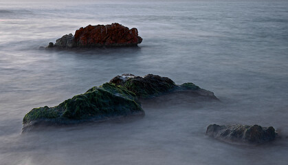 Rocks in the middle of the sea at sunrise