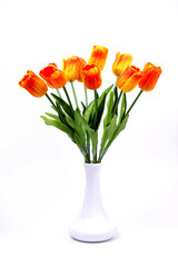 Bouquet of orange-red tulips on a white background in a vase