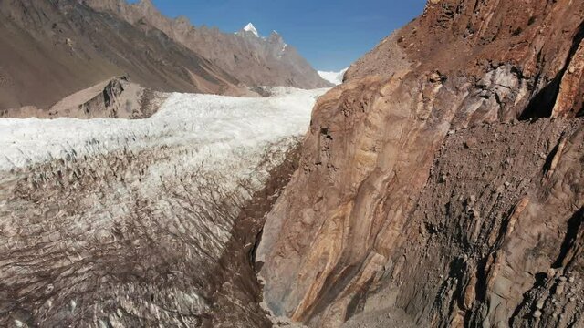 Epic rotating view of the giant Passu glacier near the Hunza valley, surrounded with arid with mountains, snowy peaks, Gilgit Baltistan region, Pakistan