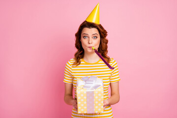 Portrait of her she nice attractive lovely cute charming funny wavy-haired girl holding in hands festal giftbox blowing whistle having fun isolated over pink pastel color background