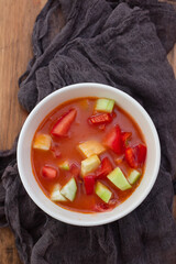 cold tomato soup gaspacho with bread in white bowl on ceramic background