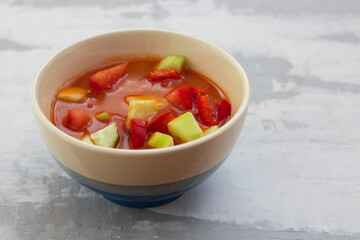 cold tomato soup gaspacho with bread in white bowl on ceramic background