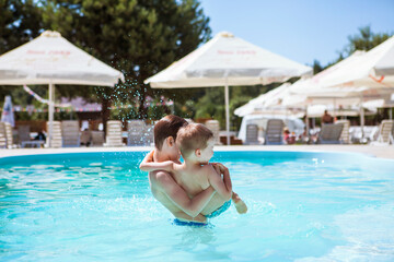 Fototapeta na wymiar Two brothers near the pool on a summer day