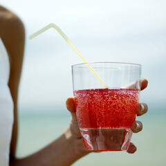 Woman holding a glass of fizzy drink