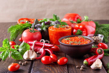 Balkan sauce ajvar and ingredients for its preparation on a wooden table. Serbian traditional food