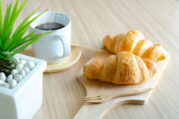Coffee croissant on wooden background empty.