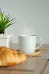 Two fresh croissants and cup of coffee on dark stone table