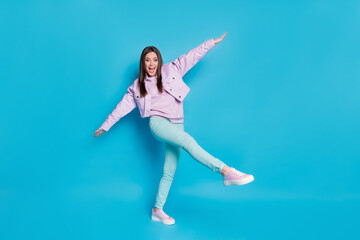 Fototapeta na wymiar Full size photo of pretty lovely content girl raise hands legs enjoy spring holiday free time wear good look clothes gumshoes isolated over blue color background