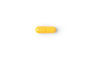 Yellow capsules or pills isolated on white background.