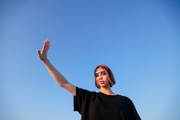 Fashion headshot of a sexy blonde woman with a make up wearing black clothes outside