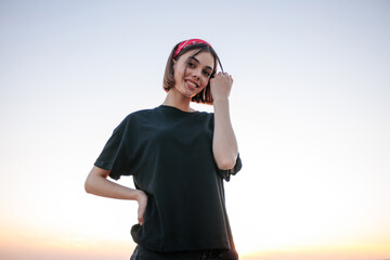 Fashion headshot of a sexy blonde woman with a make up wearing black clothes outside