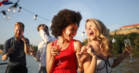Group of friends drinking, chatting and having a fun at outdoor party