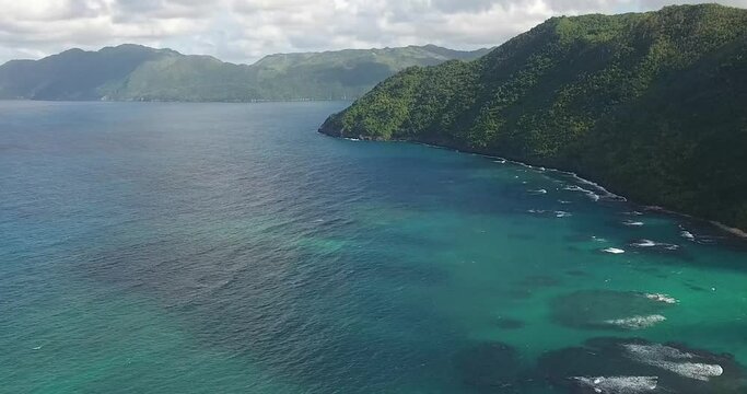 Cribbean coast with green hills and blue water bay