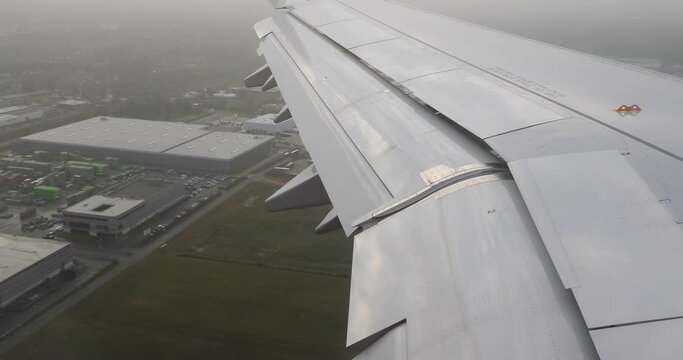 View from plane window flaps engaged on the wings during final approach and landing
