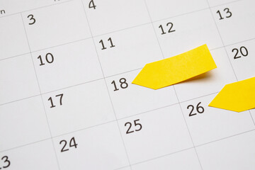 Blank yellow sticky adhesive post note paper planner with space on calendar page background for business planning appointment meeting concept