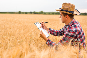 Agronomist writing on a document the wheat development plan