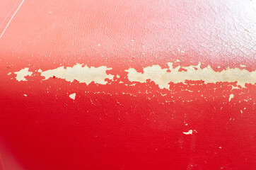 Damaged leather texture on the upholstery of the sofa and furniture. Restoration and repair, red...