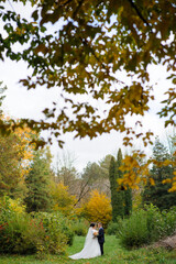 Fototapeta premium The bride and groom on the background of the autumn park.