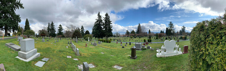 Panoramic view of a cemetery with cloudy skies and green grass in Seattle