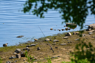 A fishing rod on the bank of a lake