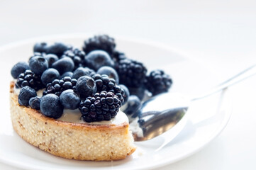 Pastry cake with blueberry and blackberry and yogurt on white plate. Delicious pie