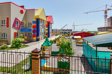 The children's playground in front of a new modern colorful kindergarten building in sunny day. Rostov-on-Don / Russia - 07 may 2019