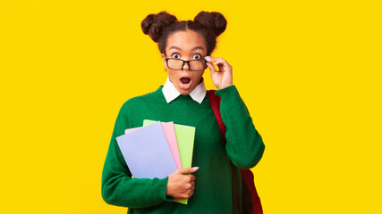 Amazed afro teenager with backpack looking at camera