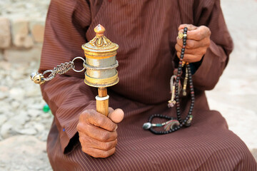 Tibetan prayer wheel in hand of old Bhutanese prayer, Hemis monastery, Leh, Ladakh.