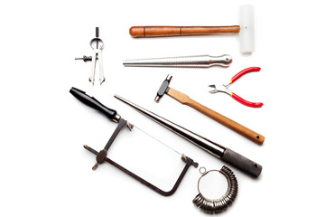 Different goldsmiths tools on the jewelry workplace. Desktop for craft jewelry making with...