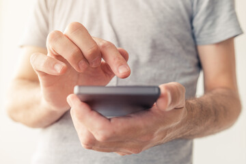 Close up of male hands typing text message on smartphone