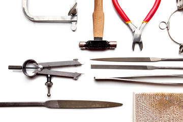 Different goldsmiths tools on the jewelry workplace. Desktop for craft jewelry making with...