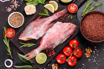 Raw fillet of red sea perch prepared for baking with spices and herbs