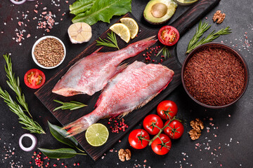 Raw fillet of red sea perch prepared for baking with spices and herbs