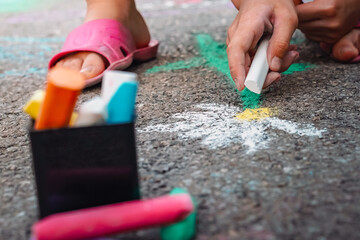 A child draws a Daisy on the asphalt, a symbol of childhood and first love, the concept of purity and innocence.