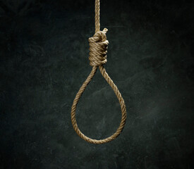 Rope noose for hangman made of natural fiber rope on a grainy gray wall. Hemp rope knot for gallows...