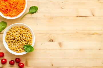 Vegetarian bowl with chickpeas and vegetables - wooden table top view copy space
