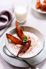 Milk Buckwheat Porridge with Caramelized Pears on grey concrete background. Healthy breakfast. Selective focus