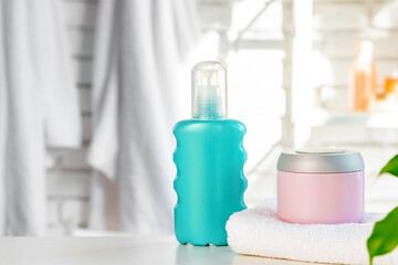 Cosmetic bottles against white bathroom wall background