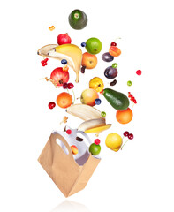 Various fruits and berries fly out from paper bag, on a white background