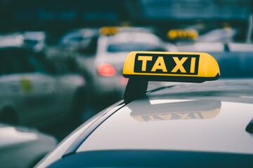 Selective focus shot of a yellow taxi sign in a traffic jam