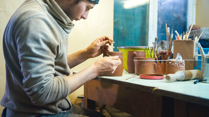 Professional ceramist working with loam at home studio. Handmade and small business concept.