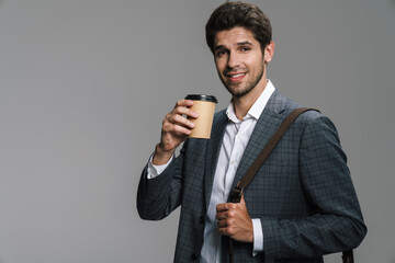 Photo of smiling confident businessman drinking coffee takeaway