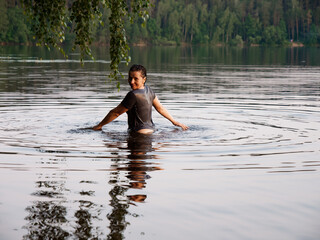 beautiful girl bathes in a lake at sunset