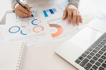 Businesswoman analyze document in his hands.Graphs and diagramm on notebook screen.
