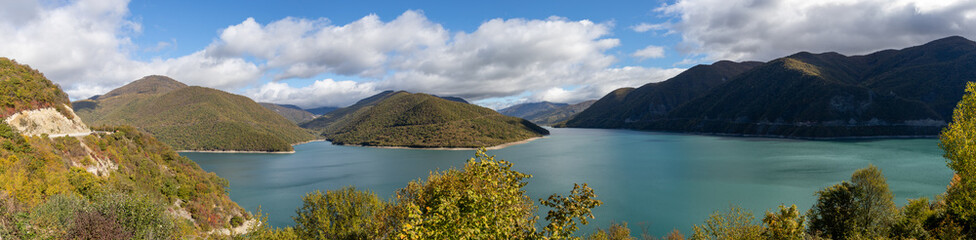Fototapeta na wymiar Zhinvali Dam Georgia beautiful lake with hills and islands, blue sky and clouds 