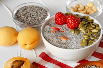 Chia pudding with strawberry and pumpkin seeds on wooden table